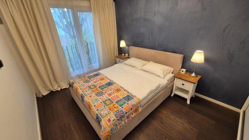 a bedroom with a bed and a window and two lamps at Cosmo Iris in Ştefăneştii de Sus