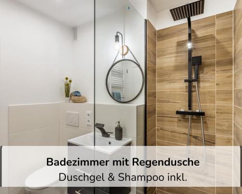 a bathroom with a shower with a sink and a mirror at Rosels Mountain Lodge - Ferienwohnung mit Schwimmbad, Sauna & Bergblick - Oberaudorf Bayern in Oberaudorf