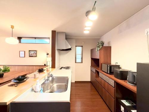 a kitchen with a sink and a counter top at NIKYO Nishi 9 Private Villa OSAKA in Osaka