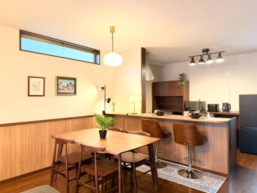 a kitchen with a wooden table and a dining room at NIKYO Nishi 9 Private Villa OSAKA in Osaka