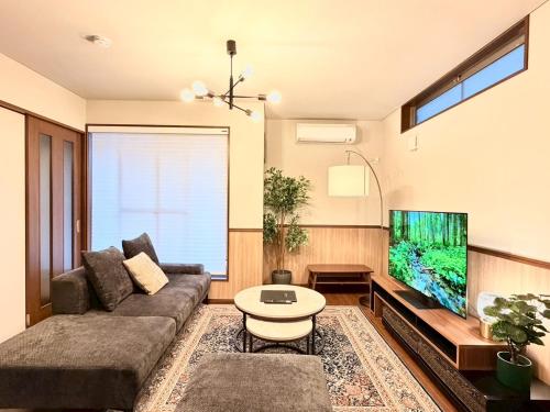 a living room with a couch and a fish tank at NIKYO Nishi 9 Private Villa OSAKA in Osaka