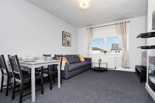 a living room with a couch and a table at Ideal Work Stays 3BR Free Parking Sleeps 6 in Falkirk