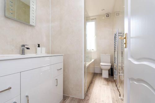 a white bathroom with a sink and a toilet at Ideal Work Stays 3BR 6 Guests Free Parking in Falkirk