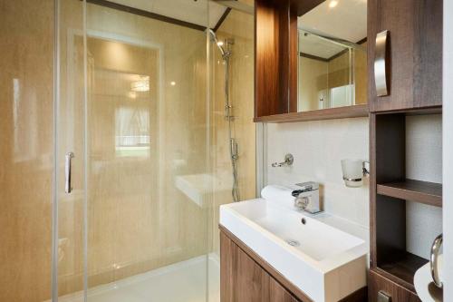 a bathroom with a sink and a glass shower at Sutton Lodge with Hot Tub in York