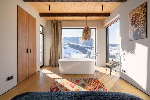 a bathroom with a tub and a large window at Emshir Villas in Krasnik