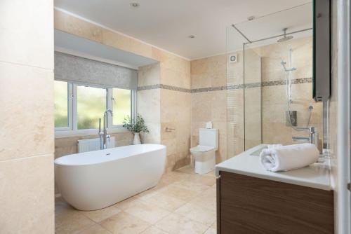 a bathroom with a tub and a toilet and a sink at Little Chy an Mor in Coverack