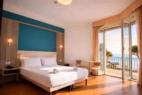 a bedroom with a large bed and a large window at LVG Hotel Collection - Majestic in Alassio