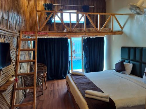 a bedroom with a bunk bed and a ladder at Bay View Resort in Anjuna