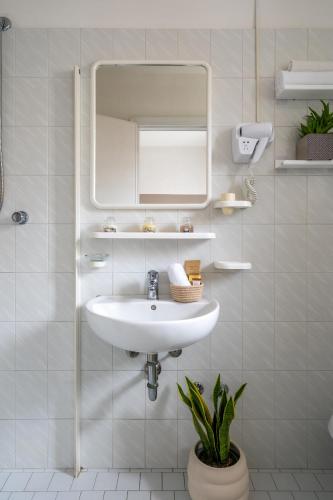 a white bathroom with a sink and a mirror at Vibe Hotel in Cattolica