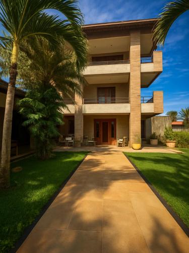 a building with palm trees in front of it at Espaço Verão Vermelho in Cabo Frio