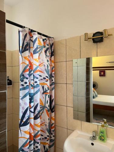 a bathroom with a sink and a shower curtain at Magenta Apartment in Diani Beach