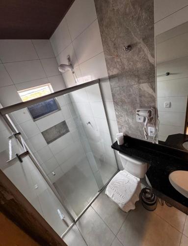 a bathroom with a shower and a toilet and a sink at Plumas hotel in Tucuma