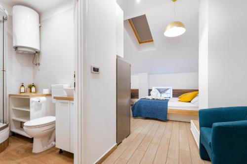 a bathroom with a toilet and a bed in a room at Apartments Pomerio Rijeka East in Rijeka