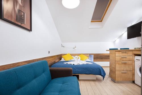 a bedroom with a blue bed and a blue couch at Apartments Pomerio Rijeka East in Rijeka