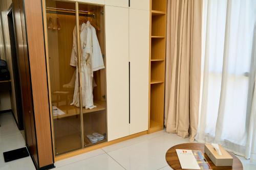 a wardrobe with glass doors and a table in a room at Dembesh Hotel Juba in Juba