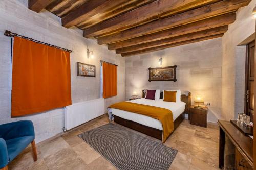 a bedroom with a bed and a chair in a room at Grand Elite Cave Suites in Göreme
