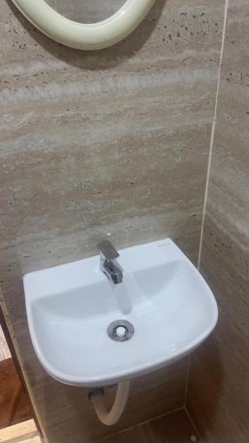 a white sink in a bathroom with a mirror at Swapnainn in Ongole