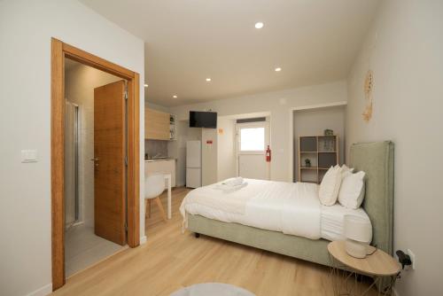 a bedroom with a large white bed and a table at City Garden House by Hosty in Sacavém