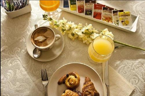a table with a plate of food and a cup of coffee at Hotel Arcobaleno in Siena