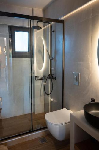 a bathroom with a shower and a toilet and a sink at KLA Luxury Boutique Villa with Pool & Jacuzzi by WESTBOOKING GR in Nikiana