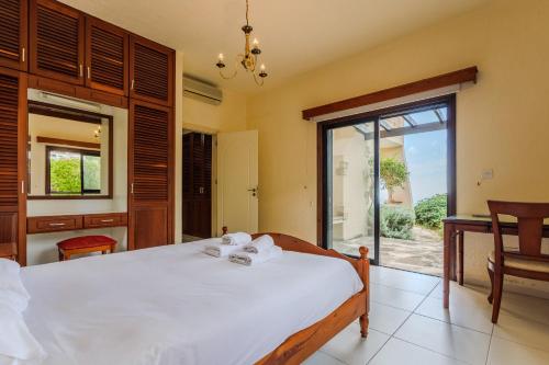 a bedroom with a bed and a large window at Resitour - Kamares Village in Paphos