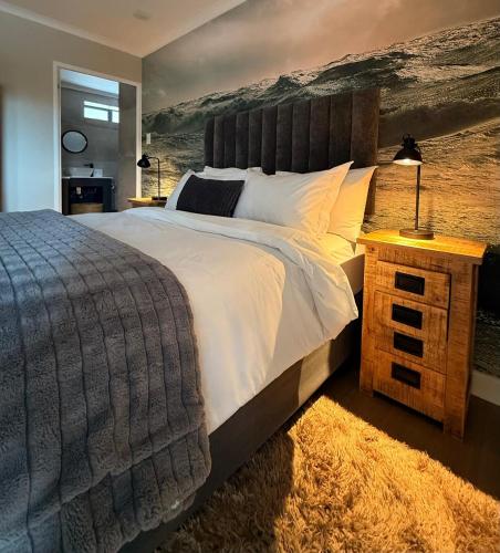 a bedroom with a large bed with a painting on the wall at Shade & Salt in Sedgefield