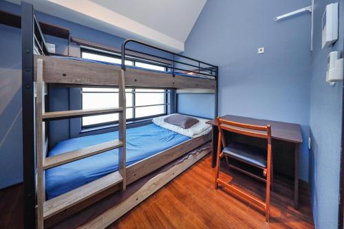 a bunk bed with a desk and a chair in a room at Stylewood Sangenjaya by Tranova in Tokyo
