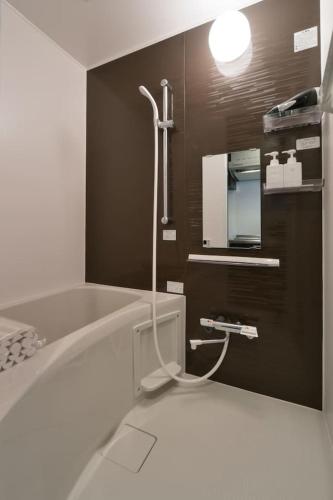 a bathroom with a bath tub and a sink at Stylewood Sangenjaya by Tranova in Tokyo
