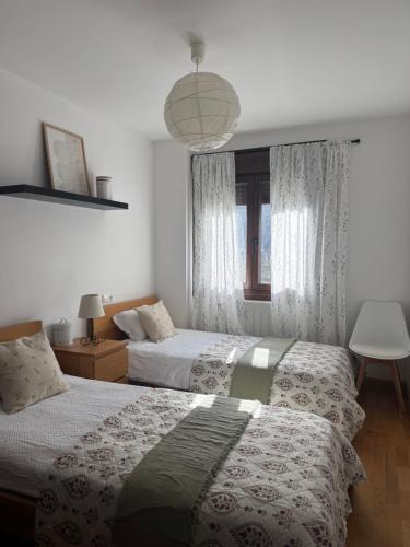 a bedroom with two beds and a window at La Terraza de Sovega in Arenas de Cabrales