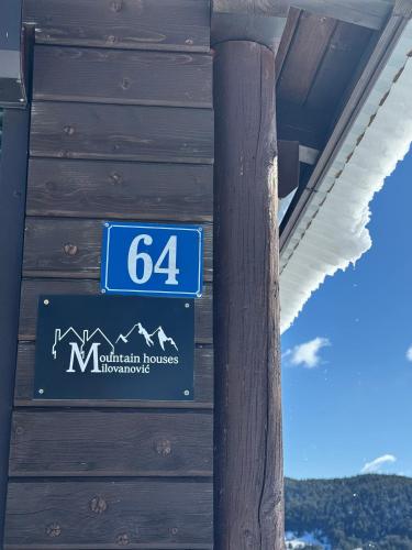 a blue sign on the side of a building at Mountain houses Milovanovic in Žabljak