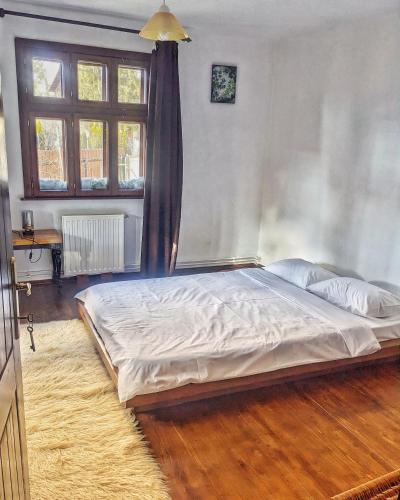 a large bed in a bedroom with a window at Thee&Thou Cottage in Breaza