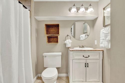 a bathroom with a white toilet and a sink at Oglethorpe Manor Garden Level in Savannah