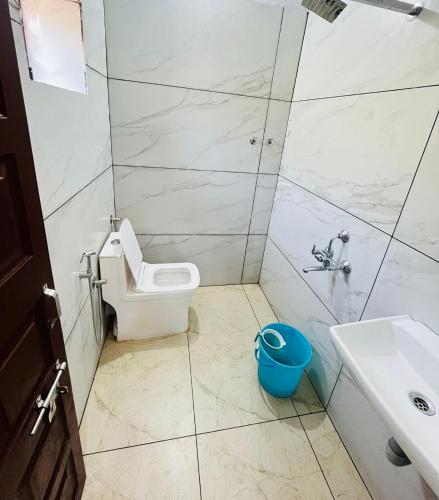 a bathroom with a toilet and a sink at Suits by lowtide in Udupi