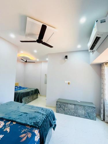 a bedroom with two beds and a ceiling fan at Suits by lowtide in Udupi