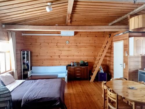 a bedroom with a bed and a wooden wall at Riverside Cottage Äänekoski Sauna Hot Tub Northern Lights in Äänekoski