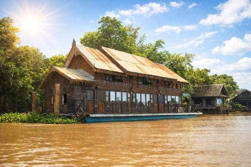 a house on a boat on a river at Rainbow Arokaya Welness Resort in Ban Hua Sai
