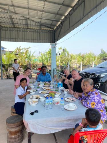 a group of people sitting around a table eating at Angkor Nature Voyages in Phumi Ta Phul