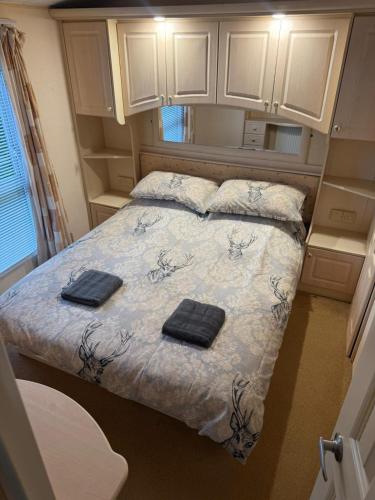 a small bedroom with a bed with two towels on it at The West Lakes Caravan in Lamplugh