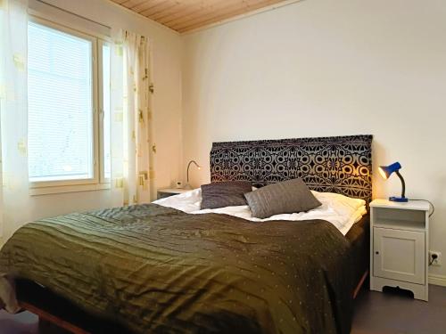 a bedroom with a large bed and a window at Villa Ilves A in Syöte