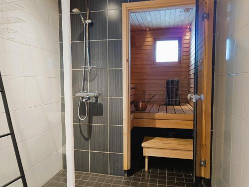 a bathroom with a shower with a bench in it at Villa Ilves A in Syöte