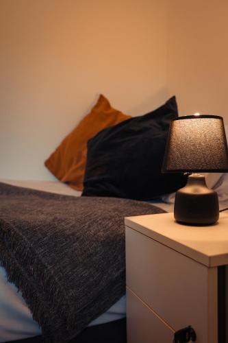 a lamp on a night stand next to a bed at The Royal Oak in Buxton