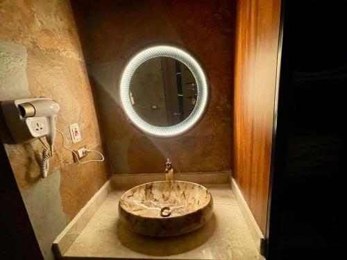 ein Badezimmer mit einem Waschbecken und einem runden Spiegel in der Unterkunft Scandic resort in Hurghada