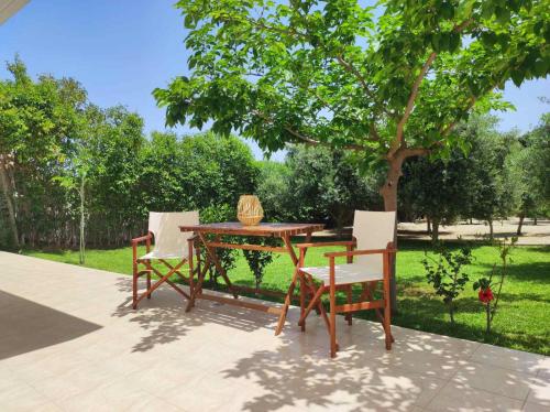 a wooden table and two chairs and a tree at Rhodes Soul Luxury Home in Asgourou