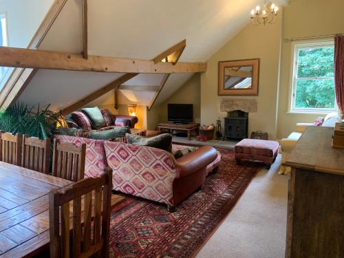 a living room with a couch and chairs in a attic at Moorgarth Hall Apartment, Ingleton, Yorkshire Dales in Ingleton