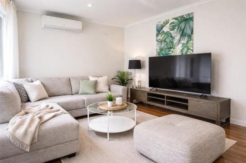 a living room with a couch and a flat screen tv at D109 Inner City Oasis on Buckingham in Melbourne