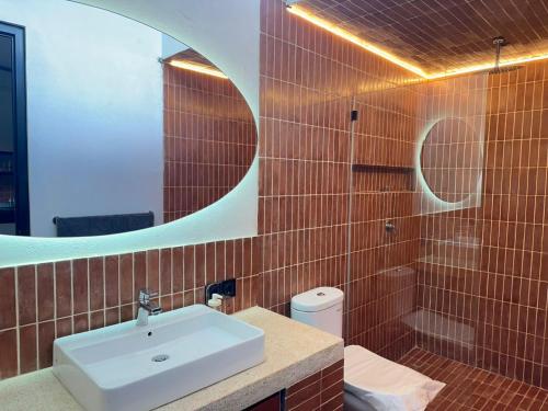 a bathroom with a white sink and a mirror at Seseh Studio in Cemagi