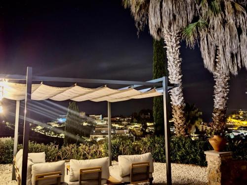 a gazebo with chairs and a palm tree at night at EVH-113 Casa Martina in Tossa de Mar