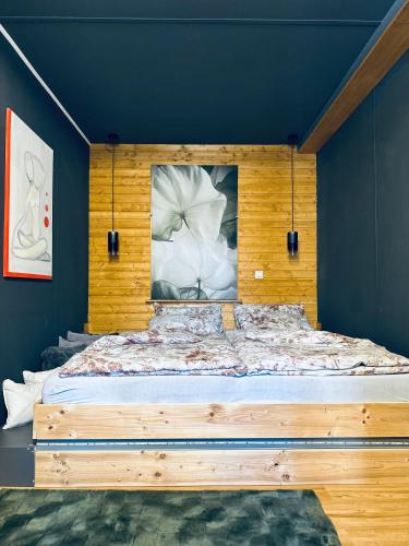 un lit avec une tête de lit en bois dans une chambre dans l'établissement Tiny House, à Tüttleben