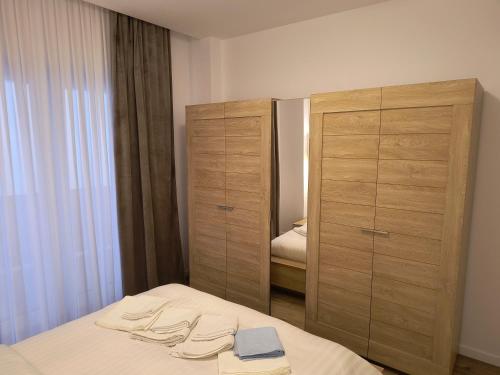 a bedroom with a bed and two wooden cabinets at Twin Constantin-Apartment in Suceava