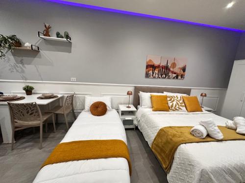 a bedroom with two beds and a dining room with a table at La Casa dell' Arco in Triggiano